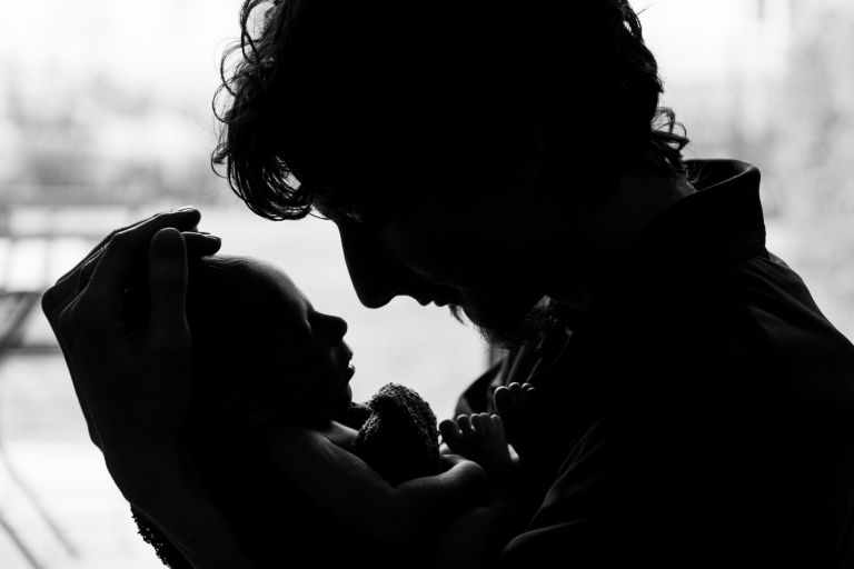 Silhouette von Vater und Baby in seinem Arm